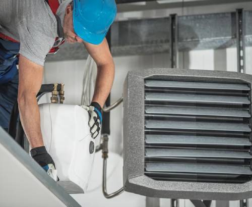 Worker placing a new air conditioning unit.